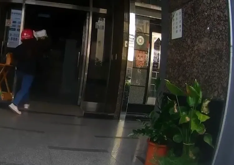 林女撿起包裹朝羅姓管理員回丟。讀者提供