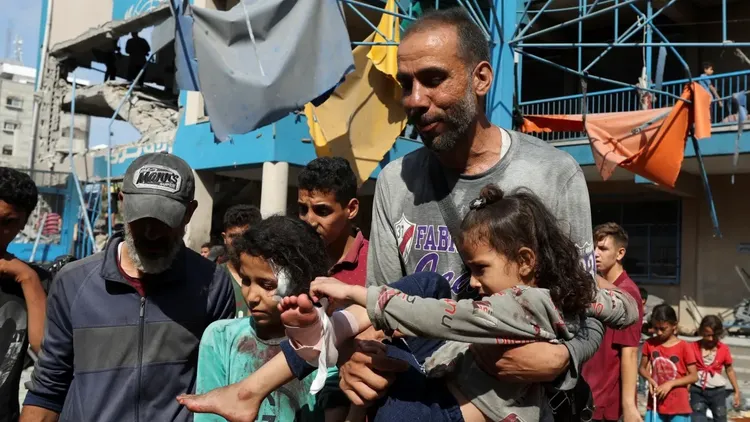 在襲擊後，一名男子勇敢的抱起受傷的孩子尋找醫療資源。路透社