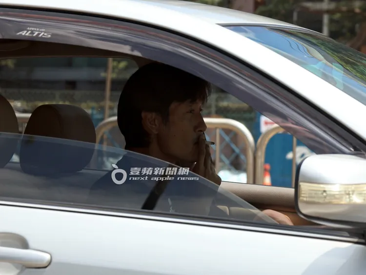 唐治平在車內吸菸，打開窗戶循環。特勤中心攝