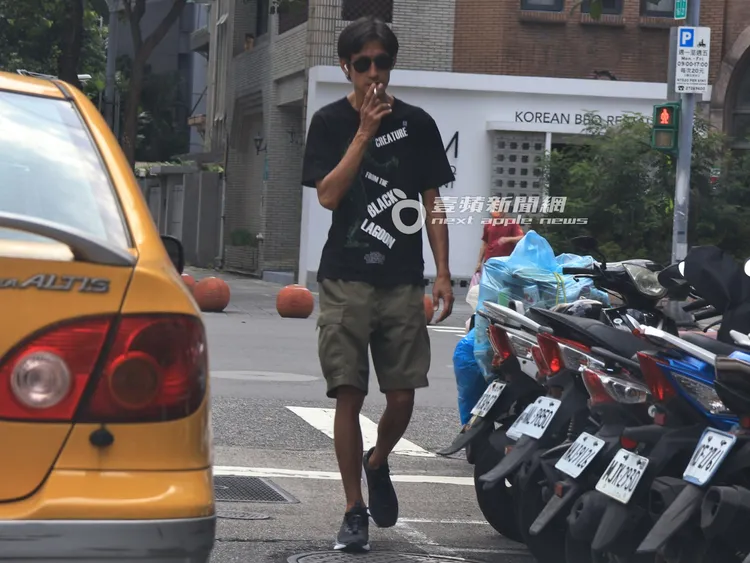 唐治平吸著香菸，逆向走在車道旁有些危險。特勤中心攝