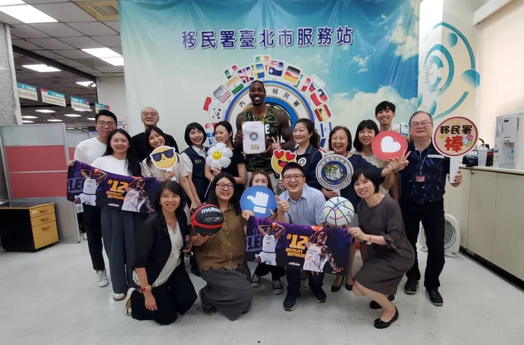 霍華德開心領到就業金卡，接受大家的祝福並合影。移民署提供