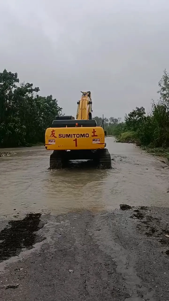 消防人員出動挖土機搶救受困河道的工人。民眾提供