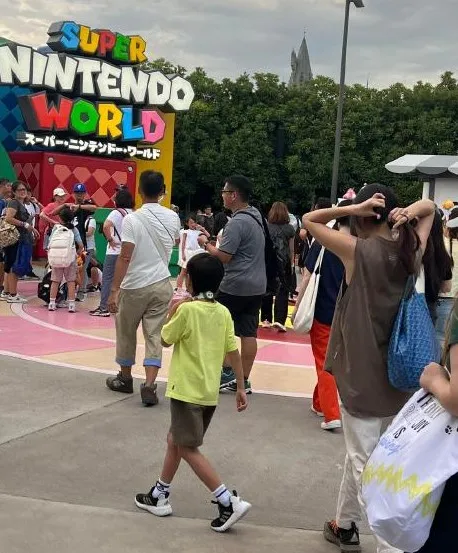 Ella邊走邊綁頭髮，7歲兒子勁寶（穿黃衣者）長大了。翻攝Jayden-小紅書