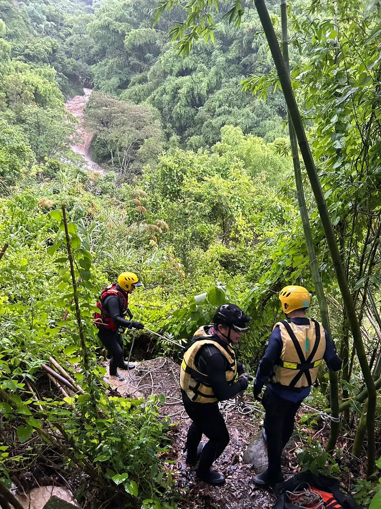 消防隊員綁著繩索，沿著崎嶇山路下切100公尺展開救援行動。