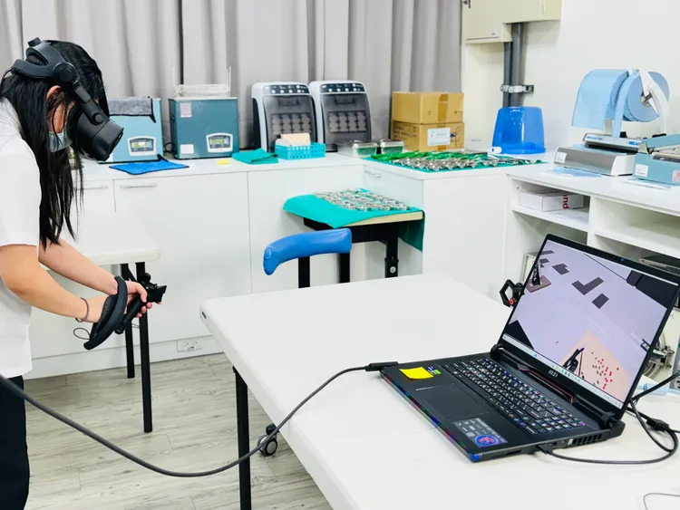 學生正在透過訓練系統模擬切菜的步驟。趙筱文 攝影。