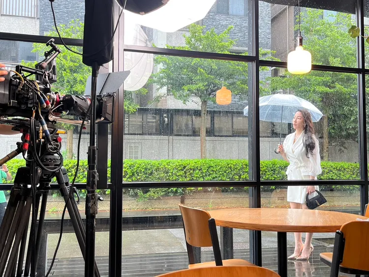 張家瑋撐傘拍《愛的榮耀》。民視提供