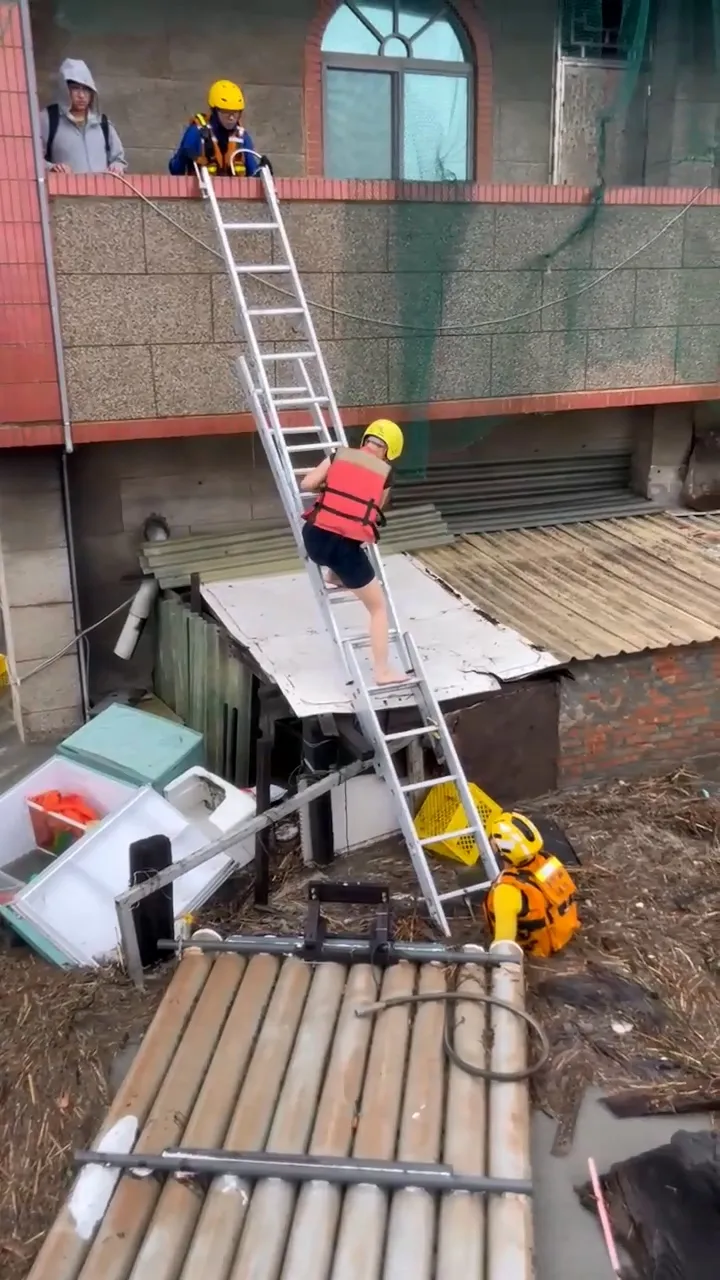 消防人員架梯協助居民脫困。民眾提供