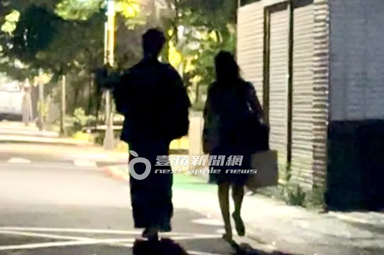 10分鐘後，李沐（右）與男友鄒序停好車，抱著一束盆栽步出停車場，再走路回家。特勤中心攝