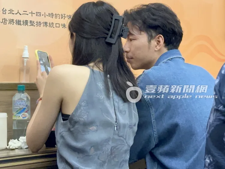 凌晨，李沐（左）與學霸男友鄒序吃陳家涼麵，看手機討論起時裝。特勤中心攝