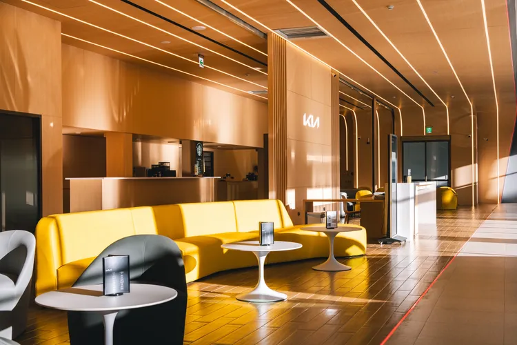 Kia高雄民族展示中心以新CI 2.0品牌識別亮相，遵循「Kia Store」的設計概念，室內利用大量暖光木質飾板，打造貼近自然、無壓力的客休沙發區。業者提供