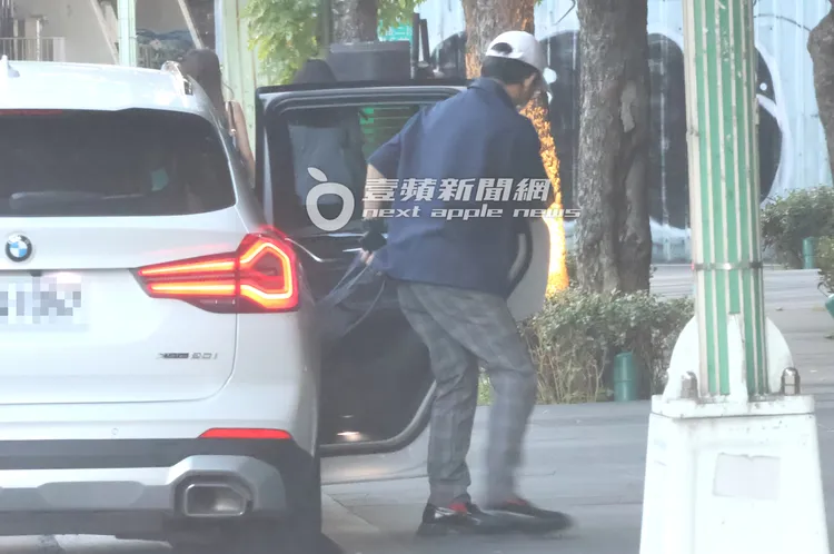 黃子佼庭審結束，拿著大袋子走下269萬BMW X3休旅車。特勤中心攝