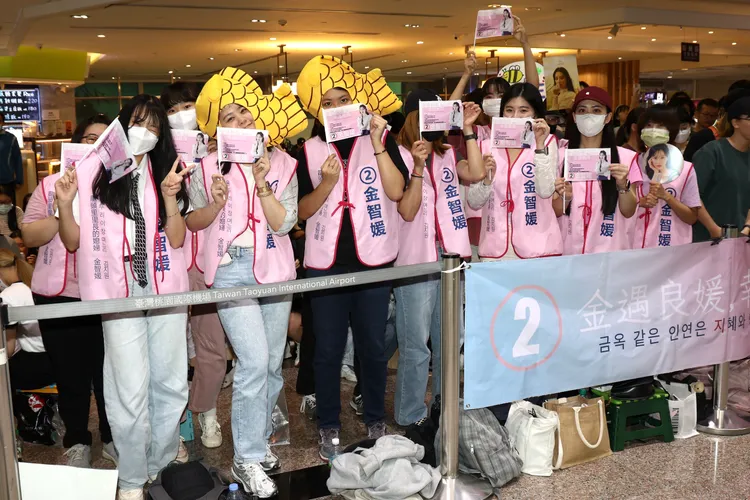 台灣秀彬群拿著特製的金智媛競選小旗子、「金玉良媛」布條大陣仗接機。彭欣偉攝