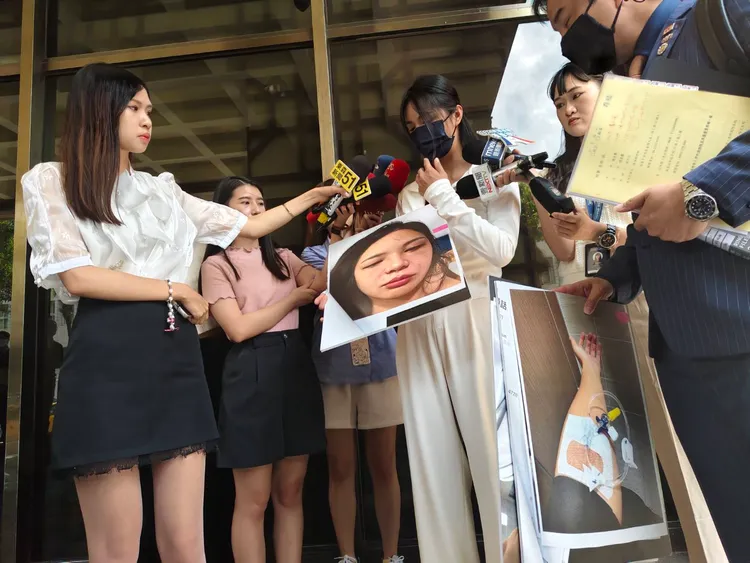 謝女秀出遭王天傑傷害的照片。張欽攝影