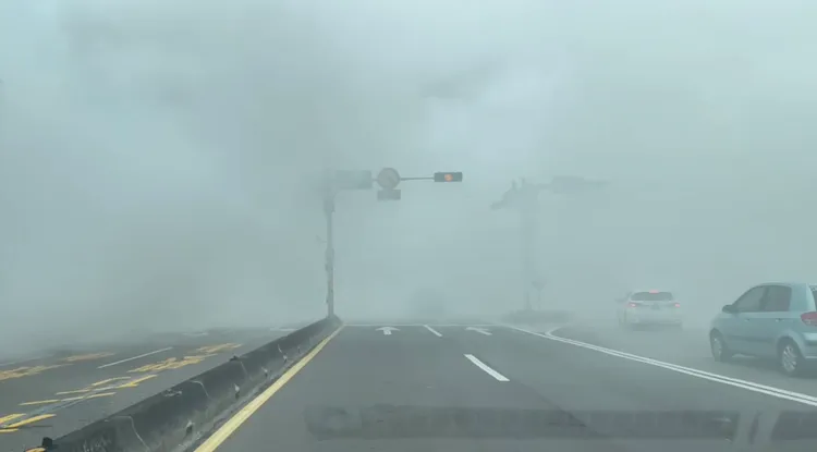 車輛經過濃煙大起，一瞬間像霧霾般連路牌都快看不見了。民眾提供