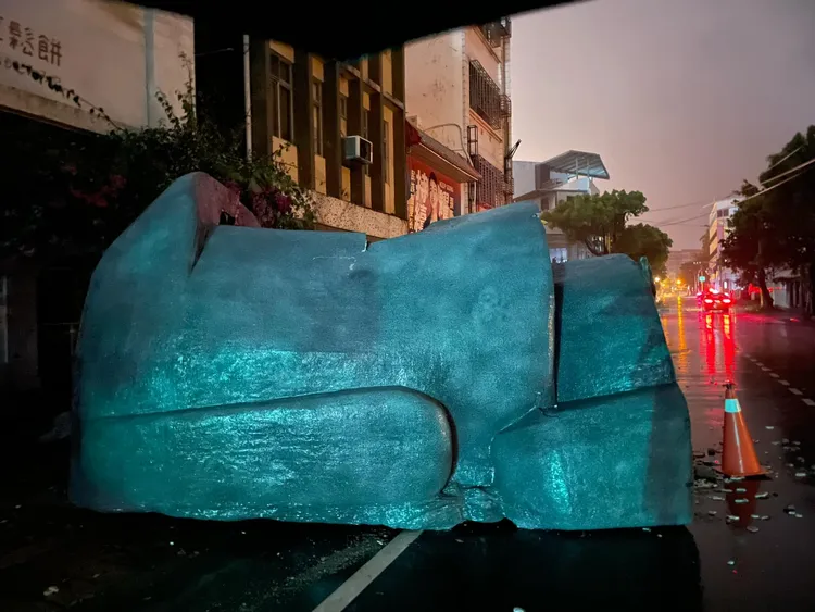 市區咖啡店屋頂大型裝置藝術被吹落路路面。民眾李木白提供