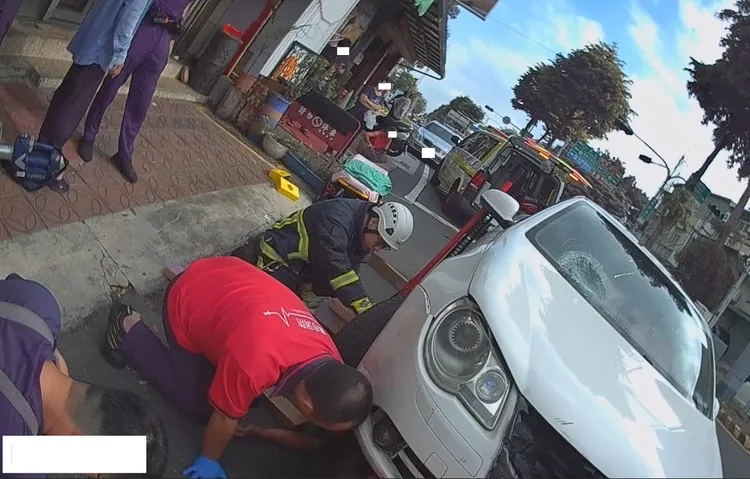 機車騎士卡在車底，警消以器材協助脫困。翻攝照片