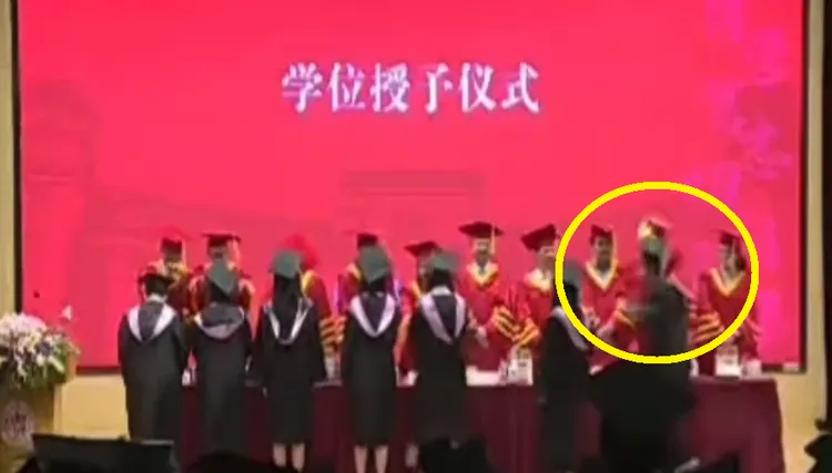 台灣夏姓學生在復旦大學畢業典禮出拳毆打中國教授（黃圈）。翻攝微博/復旦畢業打人事件