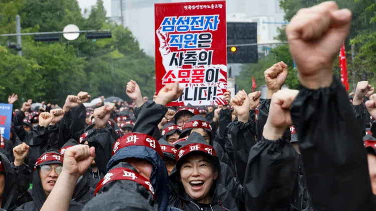 在抗議活動中三星電子員工，看板上寫著「我們員工不是消耗品！」。路透社