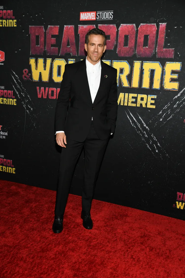 萊恩雷諾斯以簡約黑白西裝搭配Christian Louboutin黑色皮革綁帶靴。品牌提供