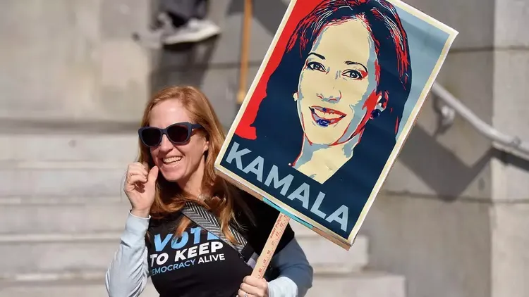 舊金山市民主黨委員會的成員舉著印有賀錦麗牌子支持她競選總統。翻攝自SFGATE