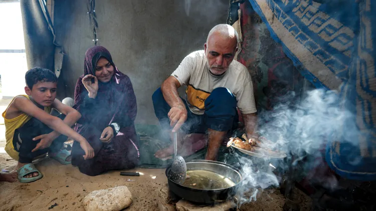 在不斷遷徙後，諾法爾在漢尤尼斯的臨時帳篷內與家人準備著午餐。美聯社