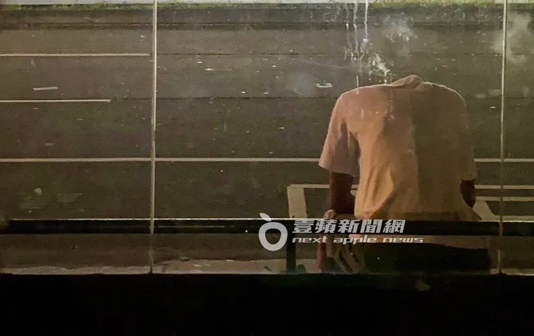 凌晨唐治平坐在松仁路上的公車等候區低著頭休息。特勤中心攝
