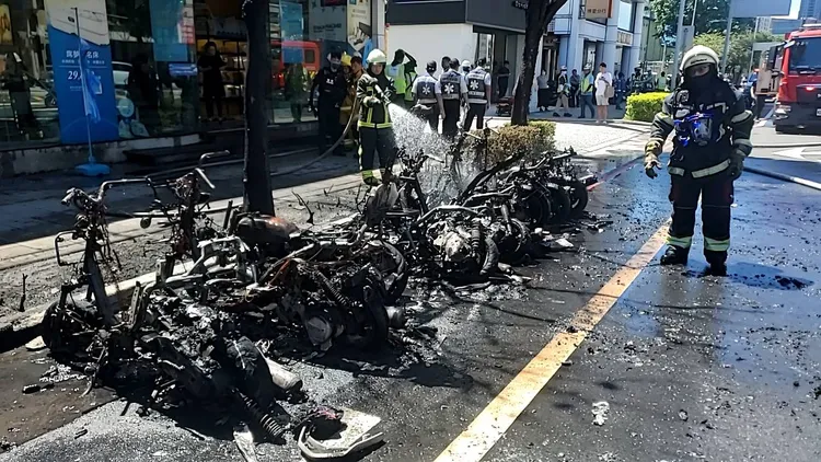 轎車疑似輾壓電池起火，火勢延燒後方機車慘燒成骨架。警方提供