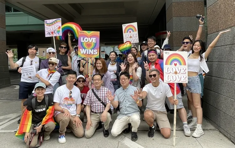 今年多倫多同志大遊行的台灣隊伍，由「寬容自信台灣協會」（Taiwan With Pride）號召組成。成員整隊出發前，與駐多倫多辦事處副處長洪松暉（前排右3）、駐多倫多僑教中心主任藍柏青（前排右2）合影。中央社