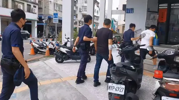 何姓父親（中）被警方帶回偵辦。民眾提供