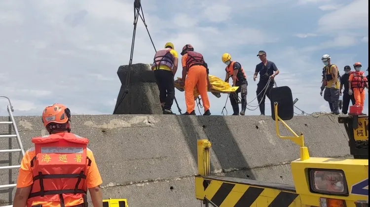 高雄中芸漁港南側防波堤外海域發現1具遺體，28日將遺體搬運上岸。翻攝畫面