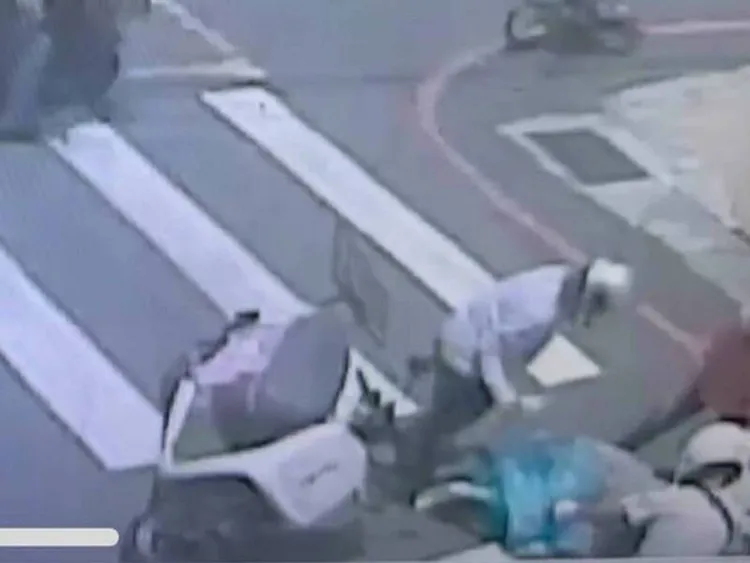 機車上兩人倒地，其中一名短裙妹痛到無法起身，熱心民眾上前幫忙。翻攝照片