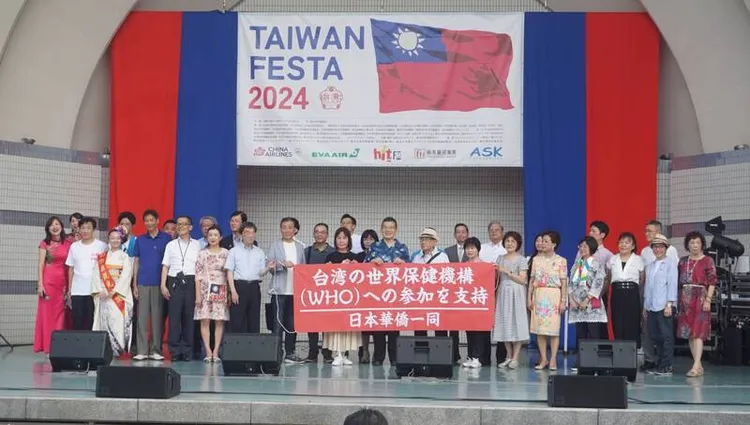 號稱日本規模最大的台灣美食活動－第7屆「台灣FESTA」，7月26至28日在東京代代木公園舉辦，會場可見中華民國國旗圖案。圖為27日開幕式，主辦單位號召日本民眾支持台灣加入世界衛生組織（WHO）。中央社