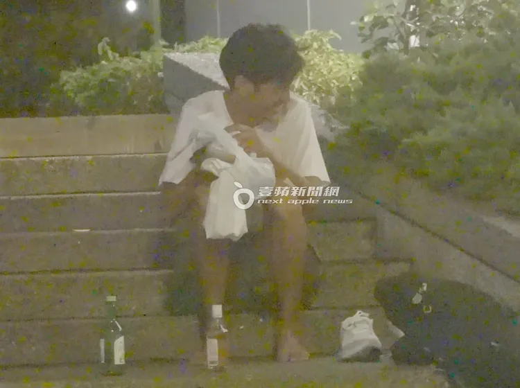 坐在階梯上的唐治平不時對著身邊傻笑。攝影中心攝