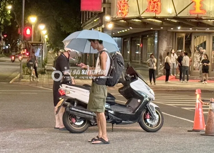 唐治平撐著藍色雨傘準備走回花博。攝影中心攝