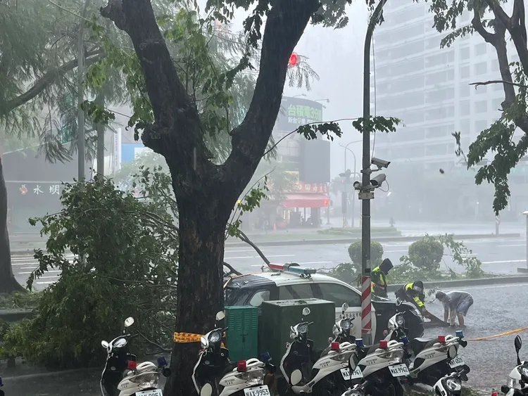 員警冒雨清理斷枝，拉出封鎖線警示。民眾提供