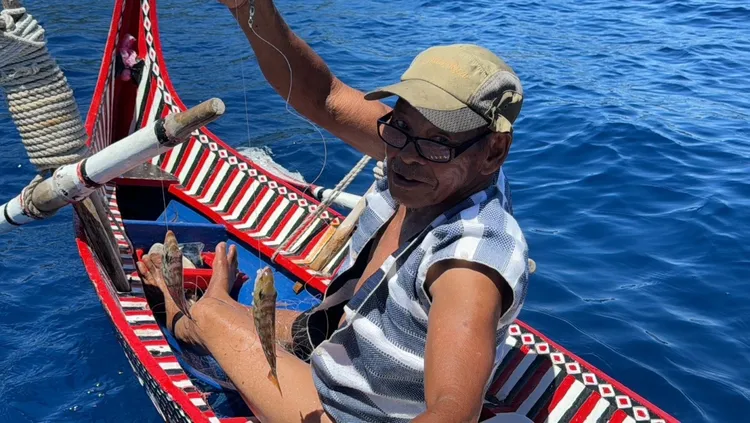 達悟族傳統漁法以手做魚線捕捉底棲魚類的「傳統魚鉤釣」。身穿傳統服飾的施清嶼耆老　簡齊儒教授提供