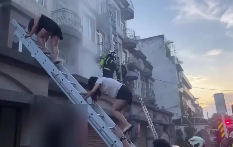 消防人員架梯協助住戶逃生。消防局提供