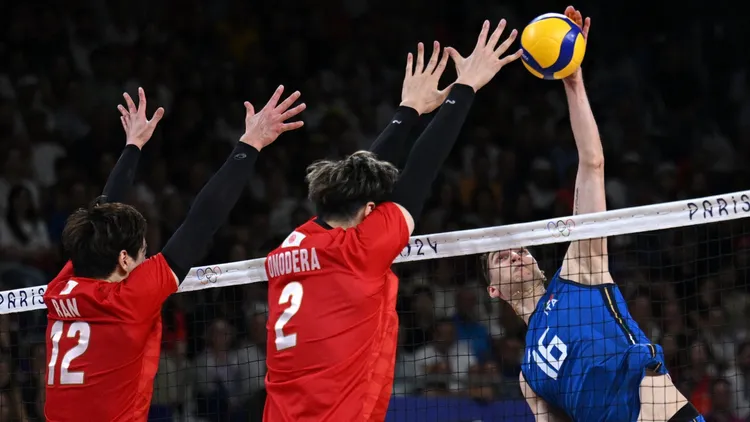 義大利球員羅馬諾（Yuri Romanò ）在空中扣殺，而日本隊小野寺太志（右）和排球新星高橋藍在空中攔網。路透社