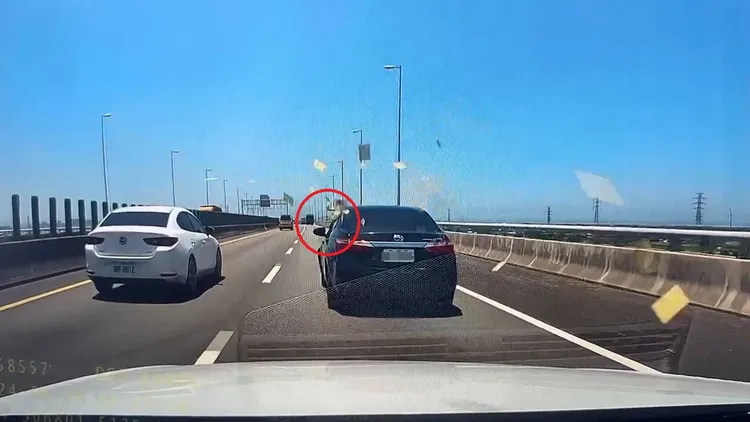 黑車駕駛打開車窗丟出一疊金紙。讀者提供