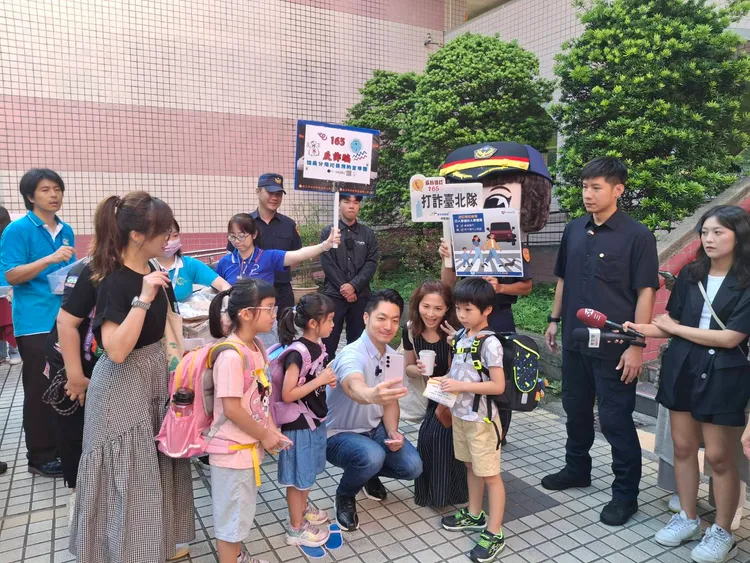 台北市長蔣萬安與大頭警察娃娃一同現身校門口，家長與小孩紛紛要求合照。翻攝畫面