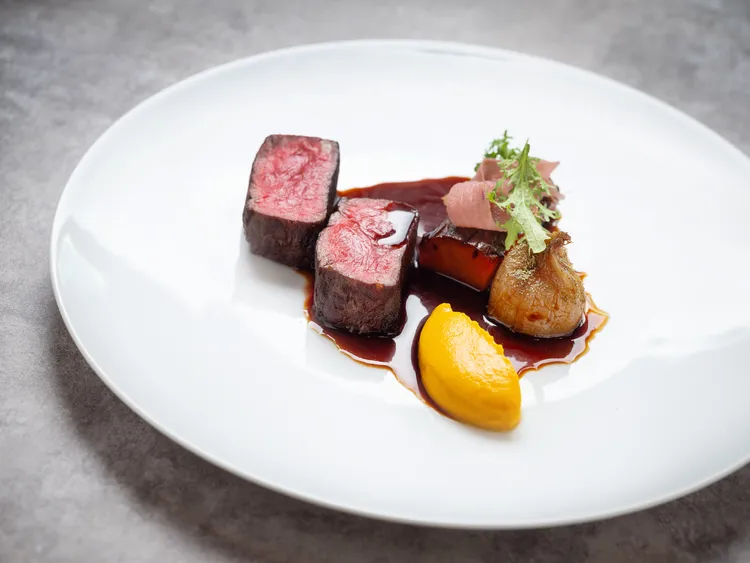 「碳烤澳洲和牛紐約客、胡蘿蔔、油封紅蔥、嫩薑、 紅酒醬汁」選用澳洲和牛的腰脊肉部位，肉質緊實富有彈性。搭以添入薑汁的胡蘿蔔泥與醃製粉紅嫩薑，點亮味蕾並清新解膩。業者提供