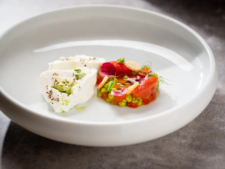「在地布拉塔乳酪、番茄、豌豆、雪豆、番茄冷湯」選用台灣甜美的櫻桃番茄，添以玫瑰陳釀的白巴薩米克醋製成冷湯，並搭配台灣布拉塔乳酪的香濃，感受涼爽芬芳的美好滋味。業者提供