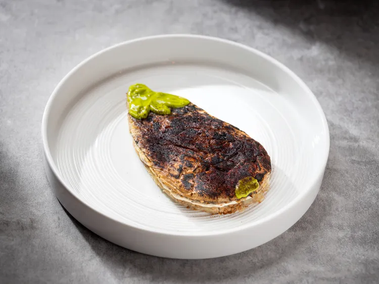 「烤茄子、酸豆鯷魚醬、油封番茄、羅勒」主廚發揮巧思，將茄子碳烤添入煙燻香氣，搭配以酸甜的油封番茄與源自皮埃蒙特的酸豆鯷魚醬，帶來新穎的視覺與味蕾體驗。業者提供