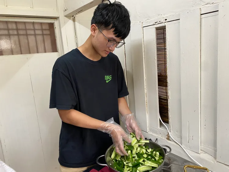 新二代承哲醃製小黃瓜，作為海南雞飯的配菜。移民署提供