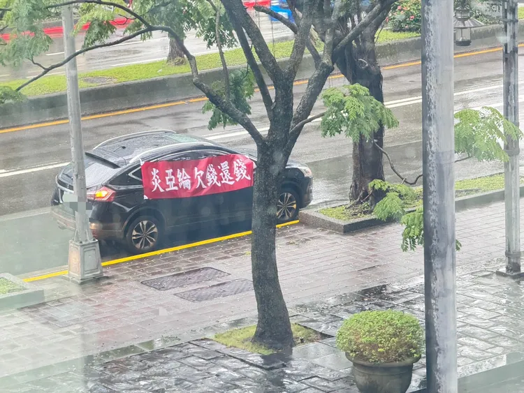 紅布條上寫「炎亞綸欠錢還錢」。彭欣偉攝