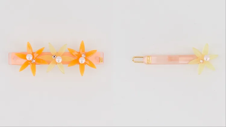 光芒小花仕女夾8公分（左）5200元、光芒小花豆扣夾黃花（右）2700元。品牌提供