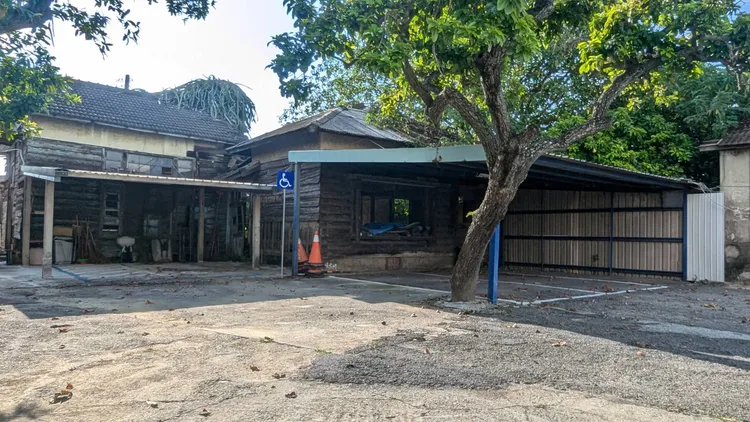 派出所後方日式木造建築已經荒廢，前方搭建停車，警方只說「仍在使用」。記者莊曜聰攝影 