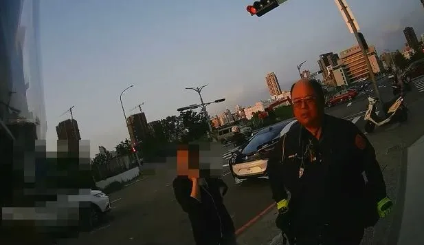 蔡姓駕駛開要價千萬的BMW電動車載女友兜風，因懸掛假車牌被攔查，女友只好站在路邊乾等。民眾提供