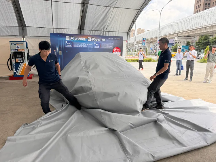 華城電能工作人員示範防火毯使用方式。呂承哲攝