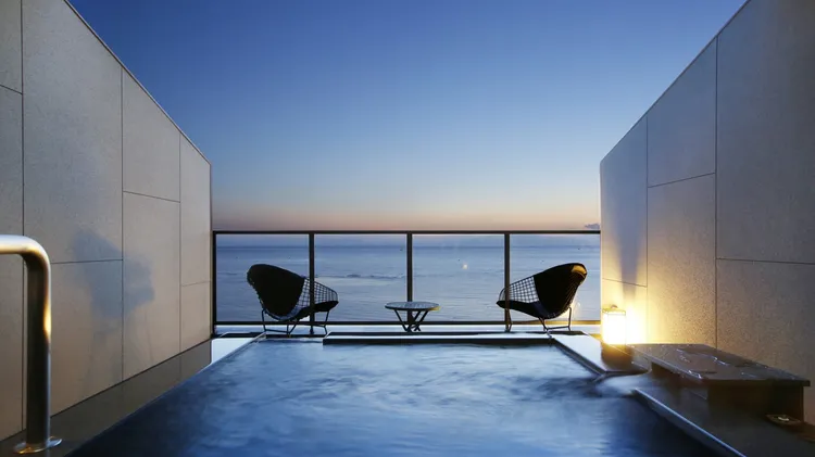 「島原海濱溫泉飯店南風樓」擁有自泉源引流的無邊際露天浴池，面朝壯麗「海天一線」的海景。業者提供